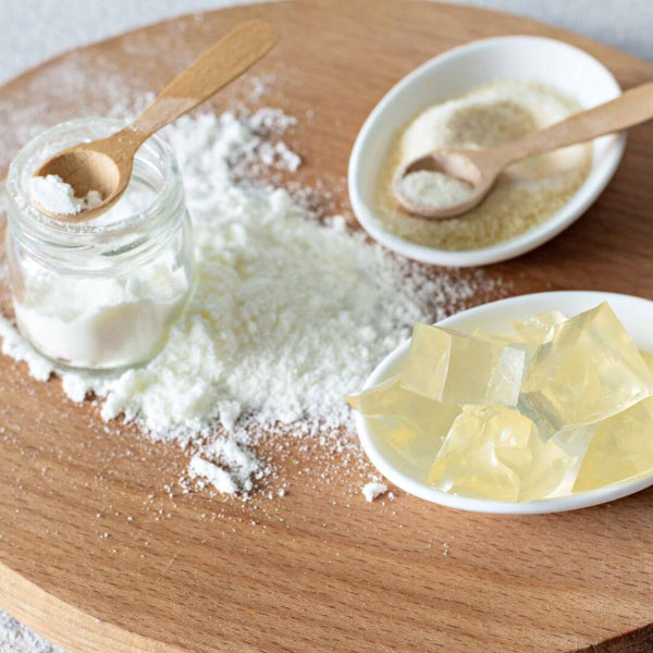 Wooden cutting board with gelatine and collagen powder, and cubes of jelly made with gelatine