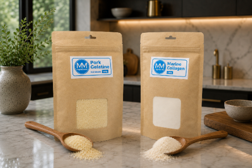 Two stand-up kraft pouches. One of  gelatine powder and the other of collagen powder on a marble countertop in a kitchen setting. The left pouch is labeled 'Pork Gelatine' and the right pouch is labeled 'Marine Collagen', each with a small window showing the powder and a wooden spoon with spilled powder in front. These are both sold by MM Ingredients Ltd